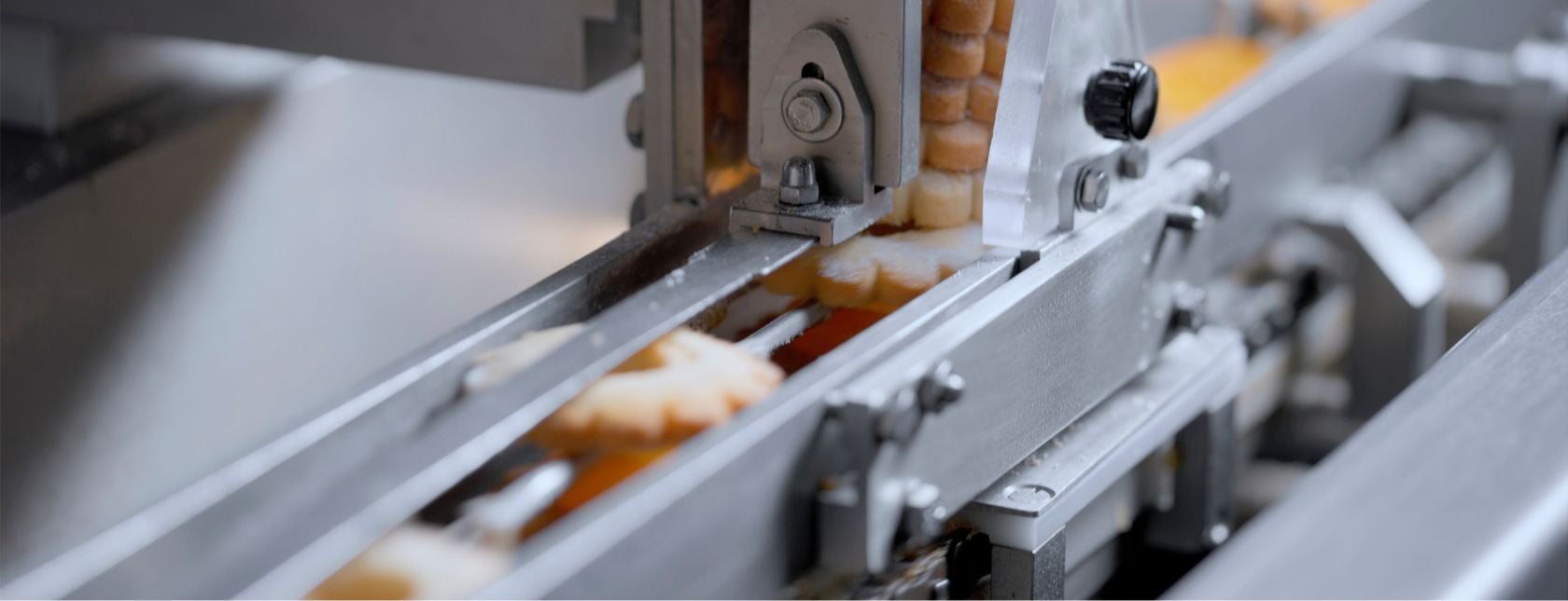 Biscoitos passando por uma máquina em uma fábrica de panificação.
