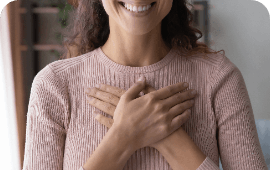 Menina com as mãos cruzadas sobre o peito