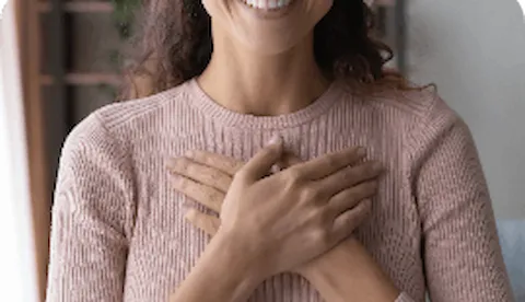 Menina com as mãos cruzadas sobre o peito