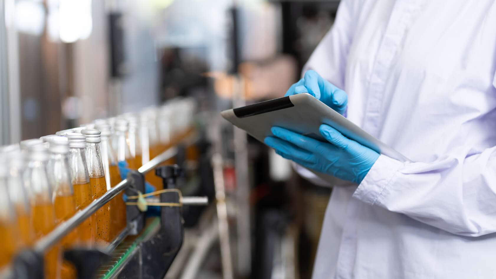 Fabricante verificando garrafas de produtos
